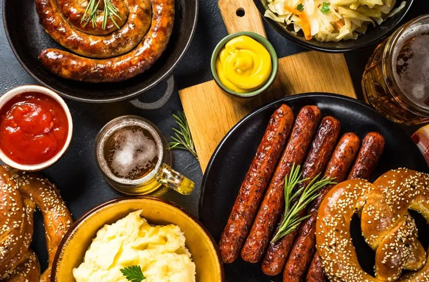 cervejas, liguiças e pães típicos da alemanha sobre um fundo preto