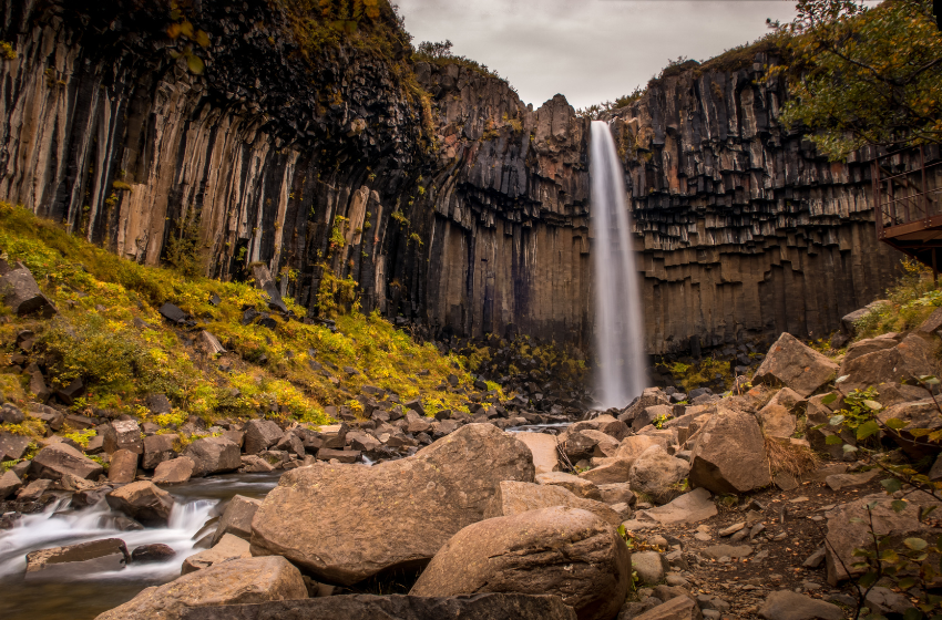 cachoeira com grande queda d'agua cercada de pedras