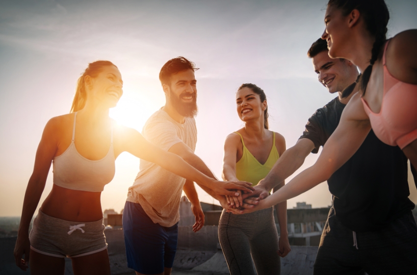 grupo de jovens sorrindo e usando roupas de exercício