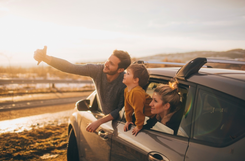 família tirando foto na janela do carro em paisagem ao ar livre