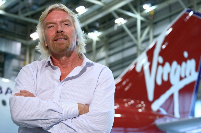 biionário richard branson em frente a um avião