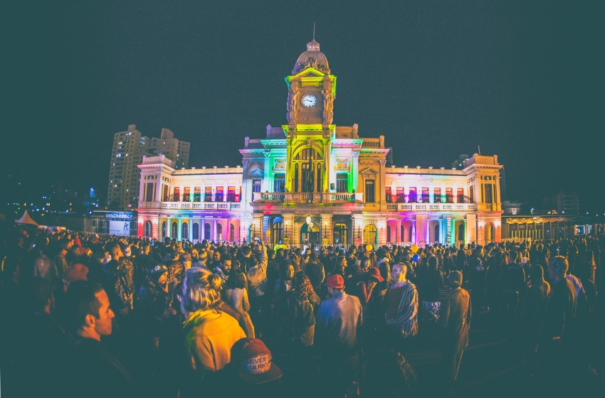 praça da estação em belo horizonte lotada de moradores e turistas com predio iluminado