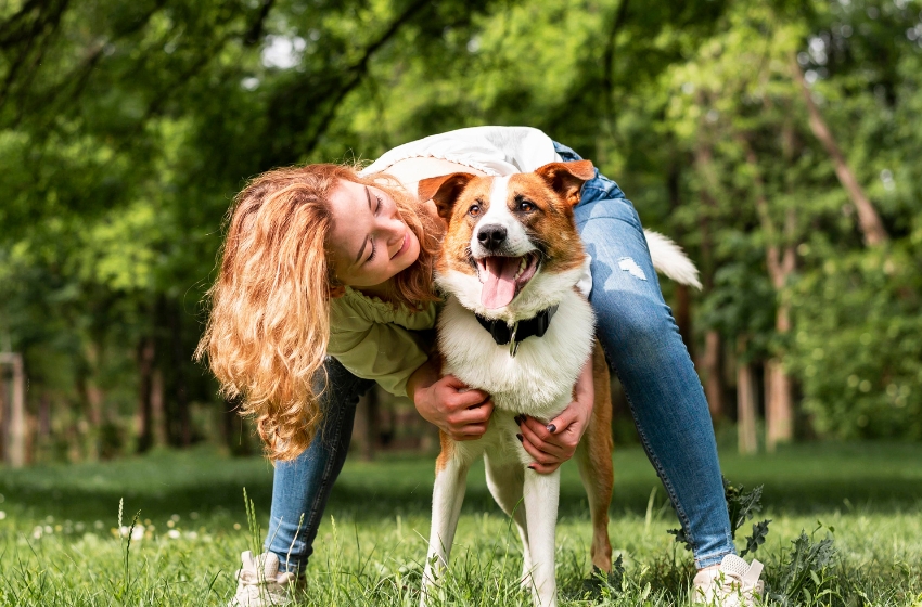 mulher loira brincando com cachorro em parque