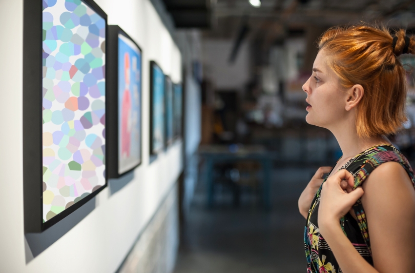 mulher observando uma obra de arte em uma galeria