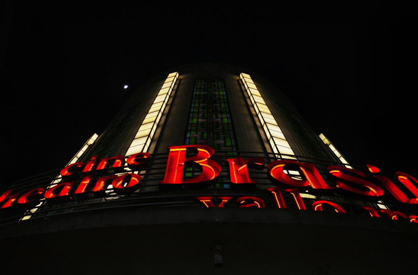 A imagem mostra a logo do Cine Teatro Brasil Vallourec, com o fundo iluminado.